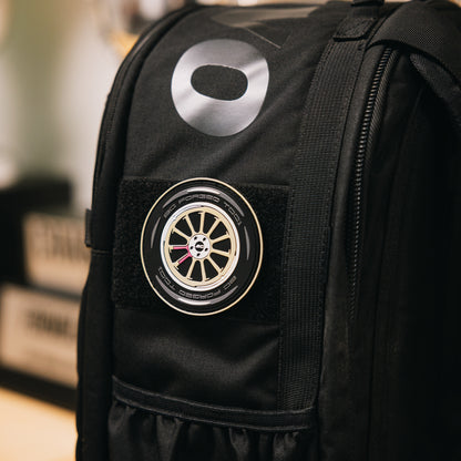 PVC patch of a BC Forged TD01 wheel in gold on a black backpack